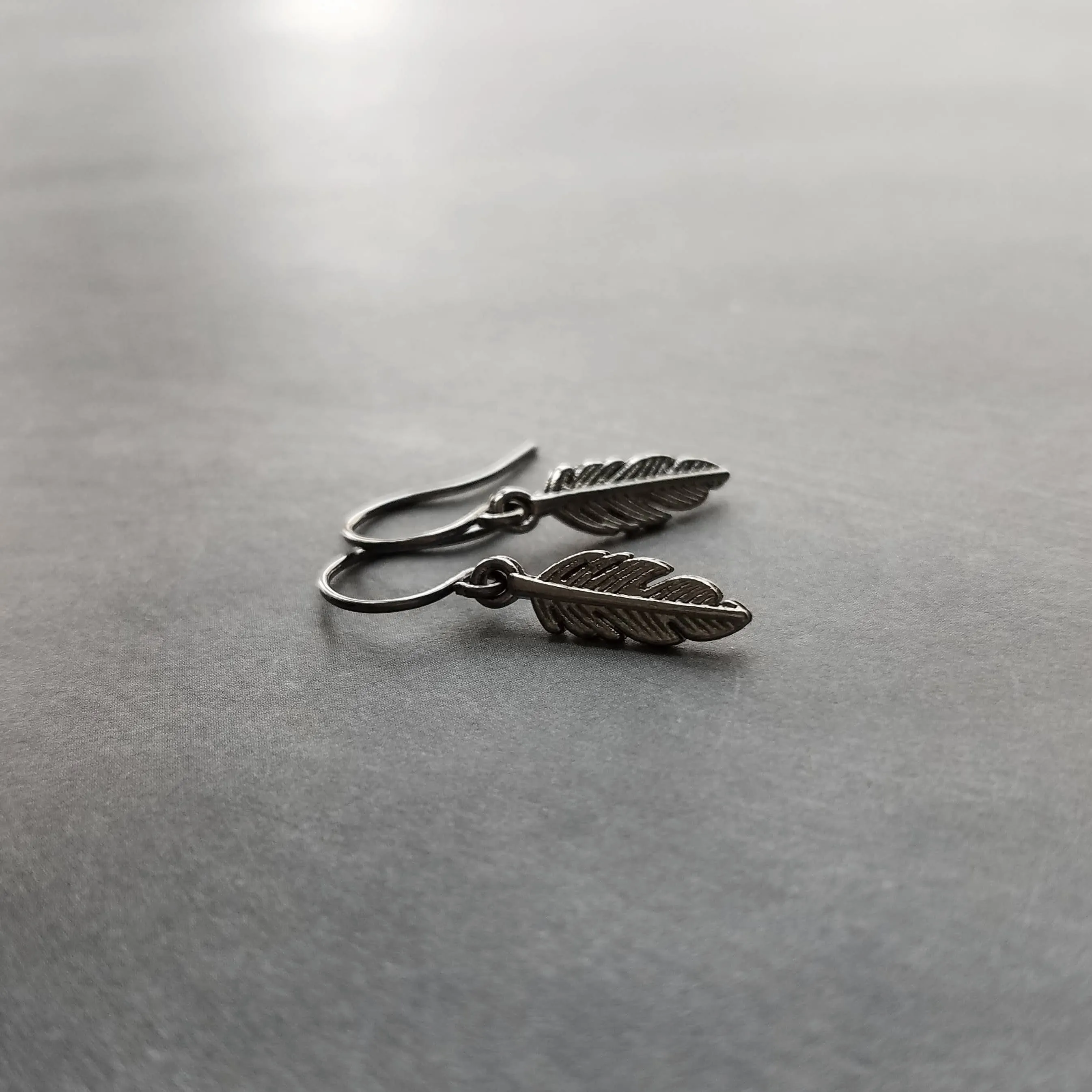 Gunmetal Feather Earrings, blackened silver feather, tiny feather earring, small gun metal feather, little feather dangle, simple feather, silvery black feather earring