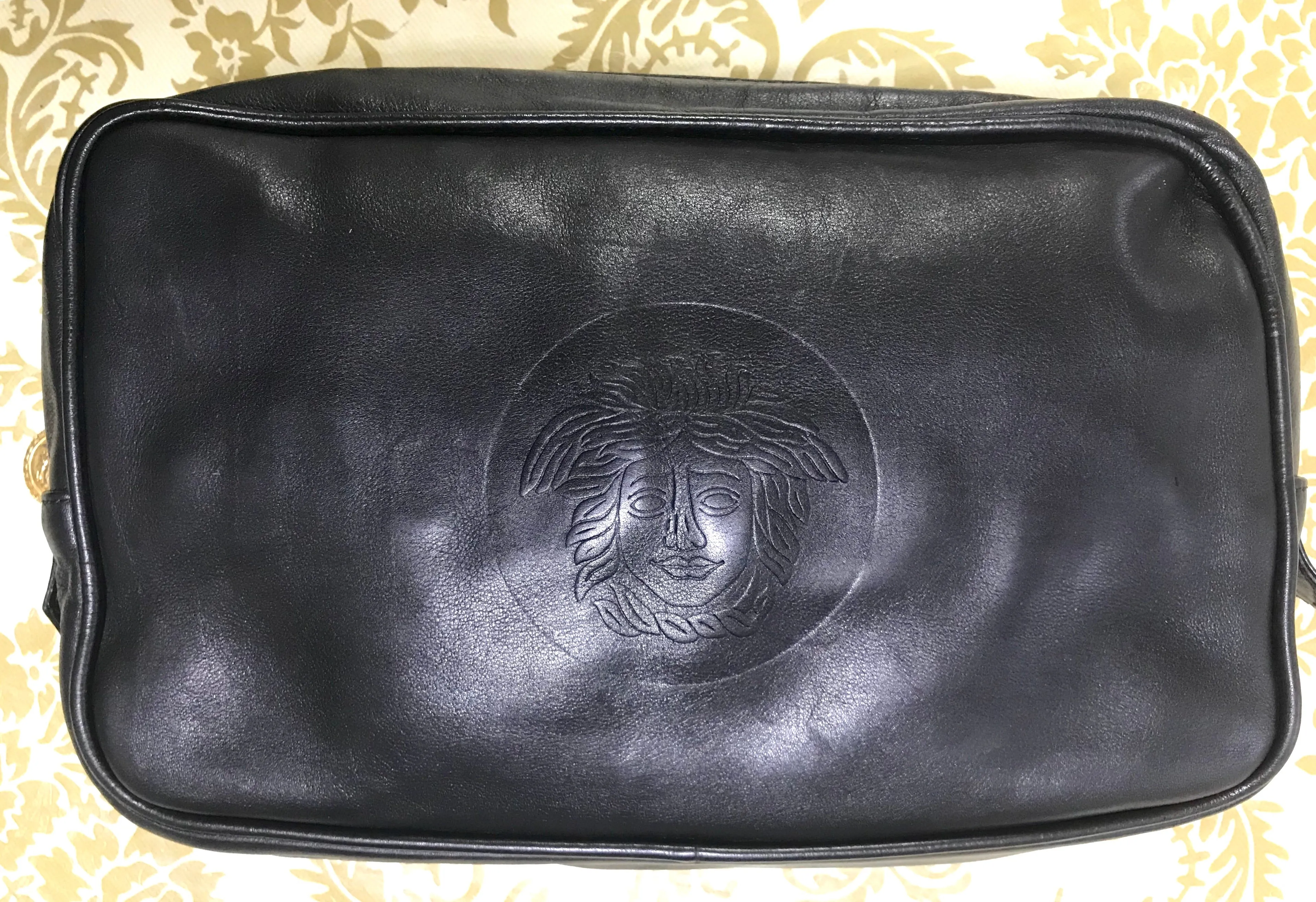 Vintage Gianni Versace black leather purse pouch, case bag with its iconic medusa face and golden logo motif charm. Unisex bag. 061122re1
