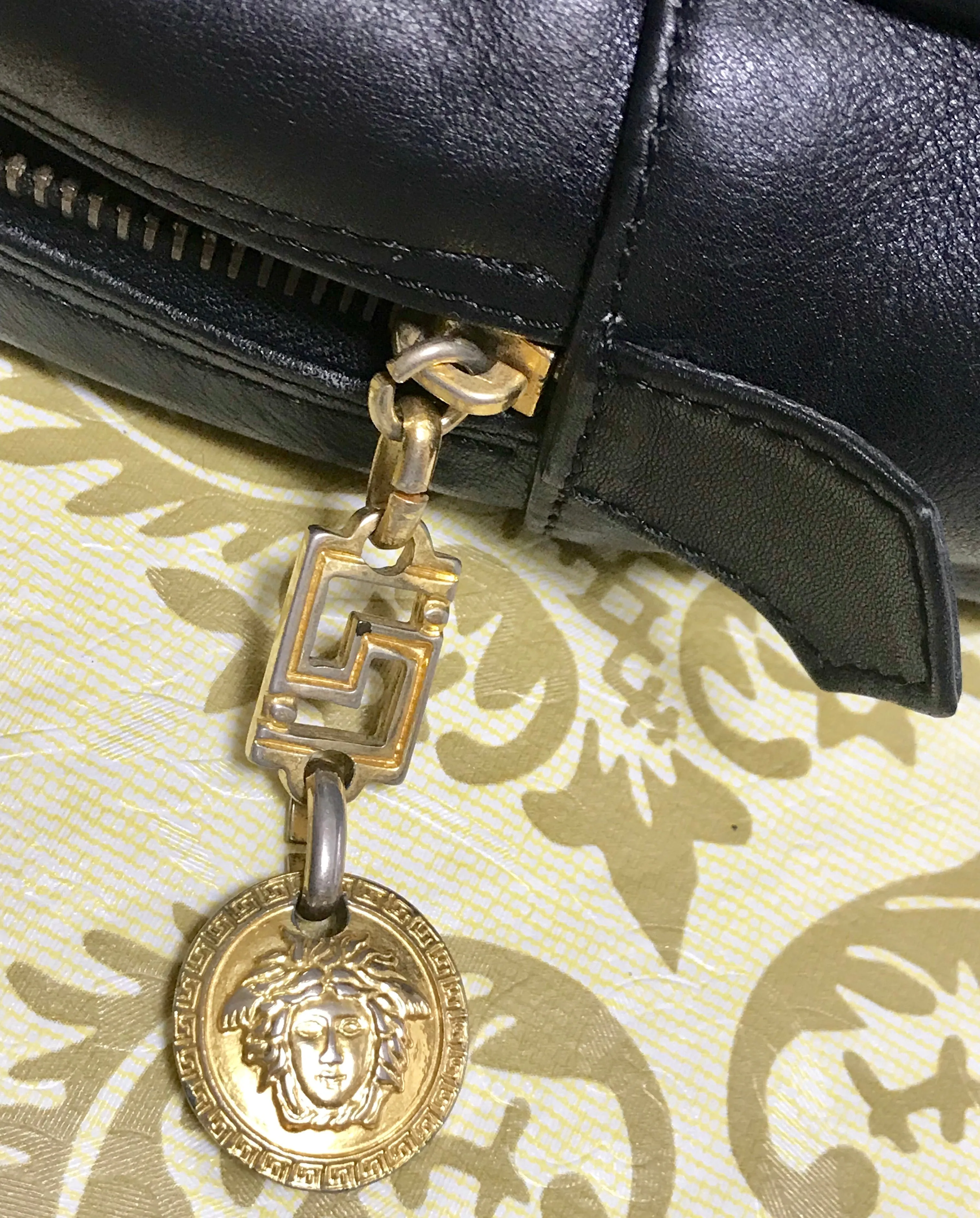 Vintage Gianni Versace black leather purse pouch, case bag with its iconic medusa face and golden logo motif charm. Unisex bag. 061122re1