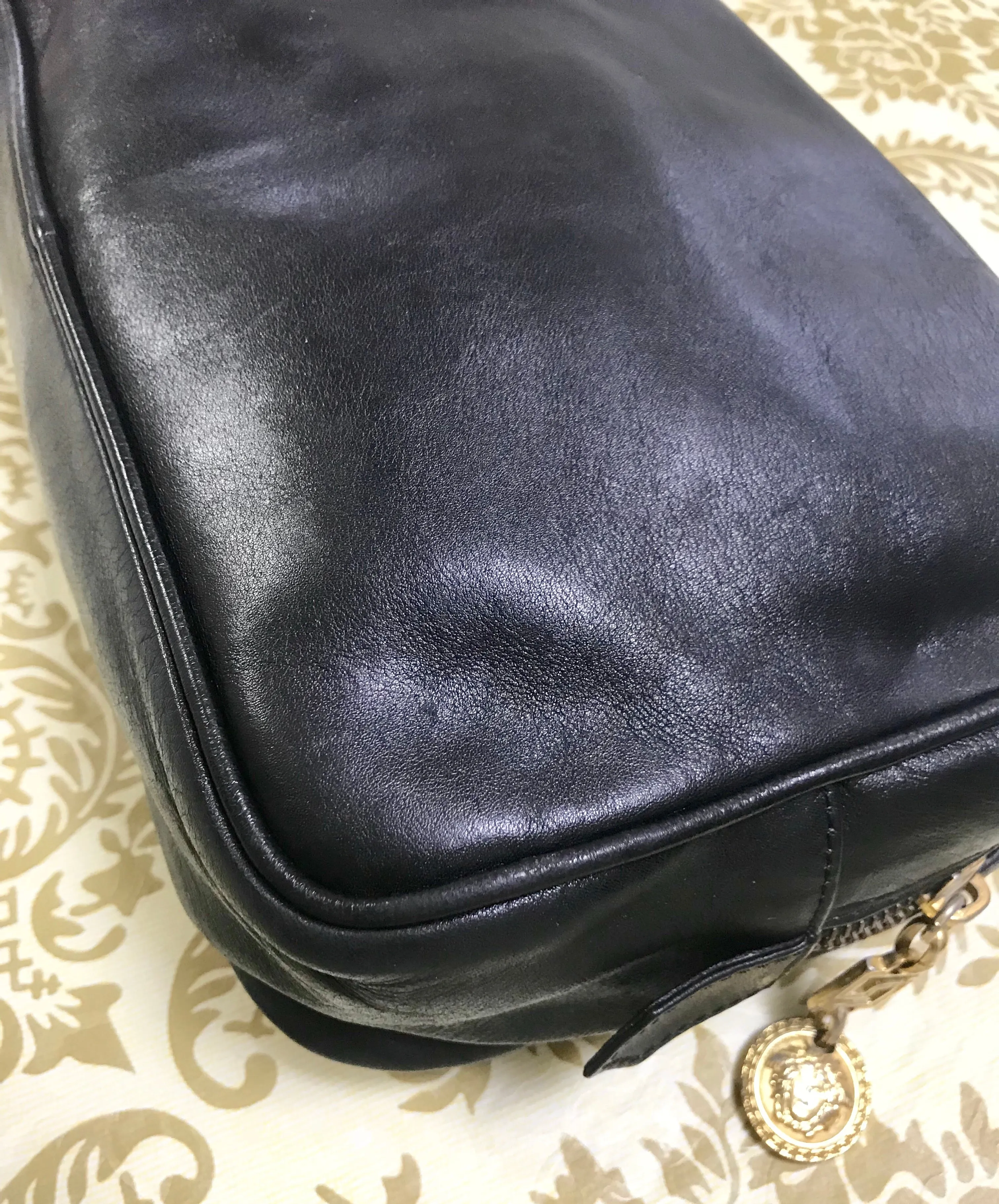 Vintage Gianni Versace black leather purse pouch, case bag with its iconic medusa face and golden logo motif charm. Unisex bag. 061122re1