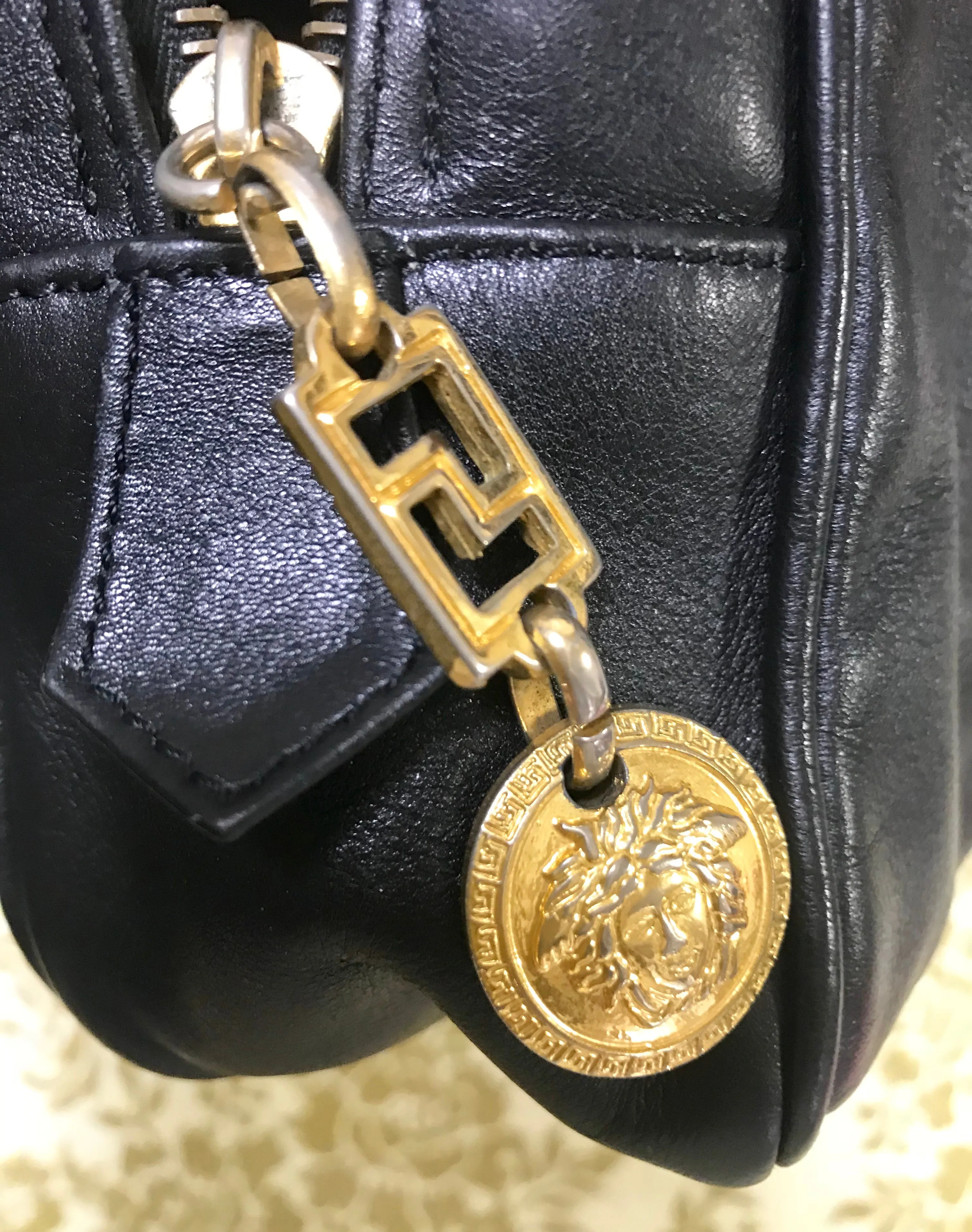 Vintage Gianni Versace black leather purse pouch, case bag with its iconic medusa face and golden logo motif charm. Unisex bag. 061122re1